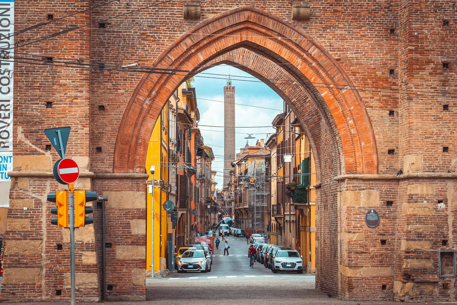 Una via del centro vista attraverso un arco, con una torre sullo sfondo